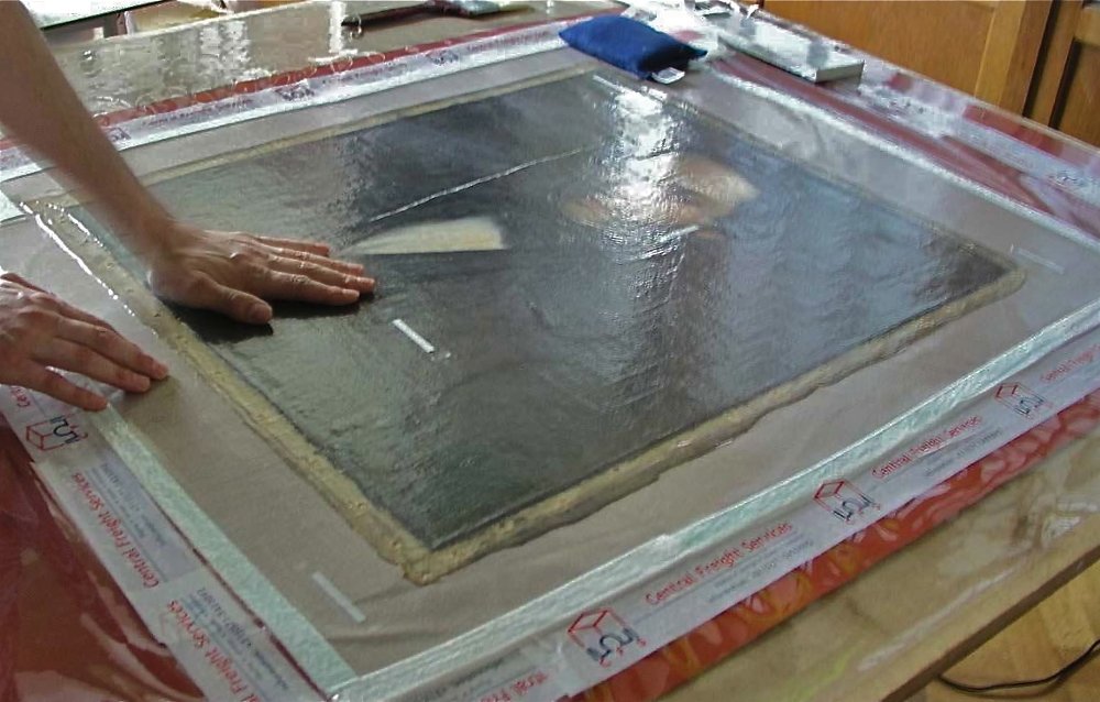The painting has been un-stretched, the tear mended and the paint losses filled up. It has been put on the lining canvas and the whole put under vacuum to insure the canvas flatness and warmed up to soften the glue which provides the adhesion